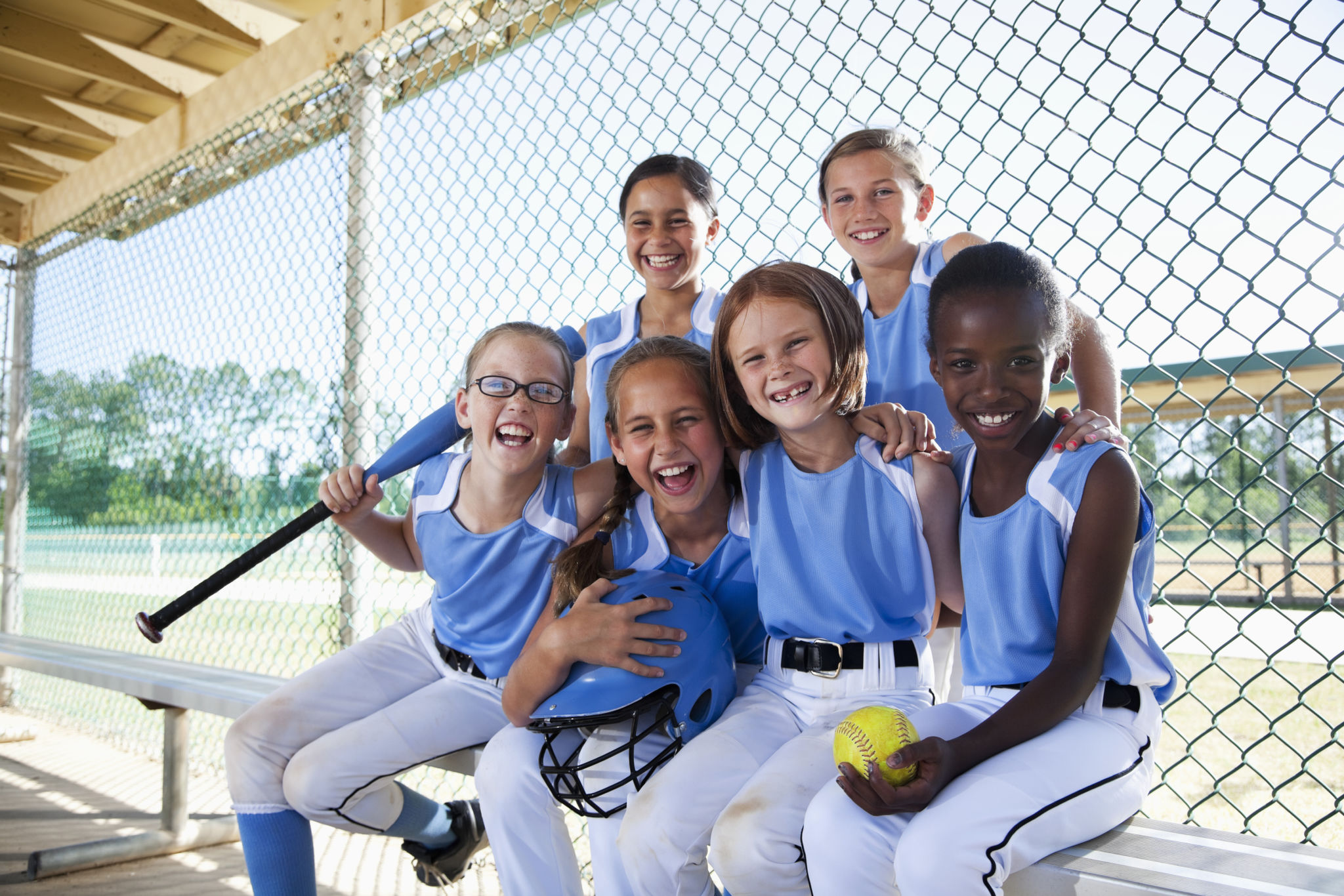 Girls softball team sitting in dugout Girls softball team sitting in dugout