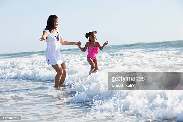 mother and daughter playing surf - mother and child in water at beach stock pictures, royalty-free photos & images
