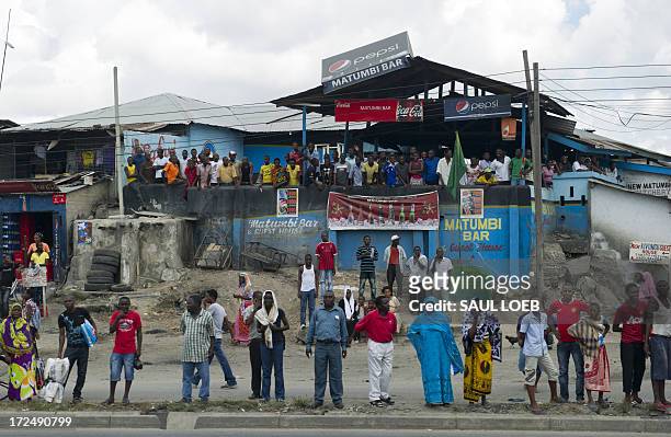 People watch US President's motorcade drive to Julius Nyerere International Airport in Dar Es Salaam, Tanzania, on July 2, 2013. US President Barack...