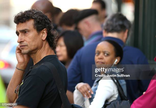 Commuters wait in line for an Alameda-Contra Costa Transit bus to arrive on July 2, 2013 in Oakland, California. For a second day, hundreds of...