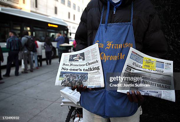 Newspaper vendor sells papers as commuters wait in line to board an AC Transit on July 2, 2013 in Oakland, California. For a second day, hundreds of...