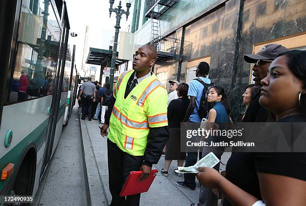 An Alameda-Contra Costa Transit worker monitors the capacity of an AC Transit bus on July 2, 2013 in Oakland, California. For a second day, hundreds...