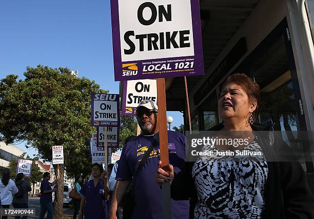 Bay Area Rapid Transit union workers with SEIU Local 1021 hold signs as they picket in front of the Lake Merritt station on July 2, 2013 in Oakland,...