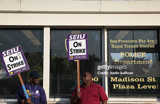Bay Area Rapid Transit union workers with SEIU Local 1021 hold signs as they picket in front of the Lake Merritt station on July 2, 2013 in Oakland,...