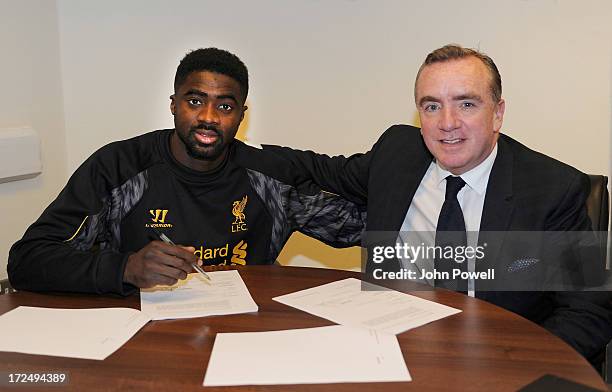 Kolo Toure of Liverpool signs a contract for Liverpool Football Club with Managing Director Ian Ayre at Melwood Training Ground on July 2, 2013 in...