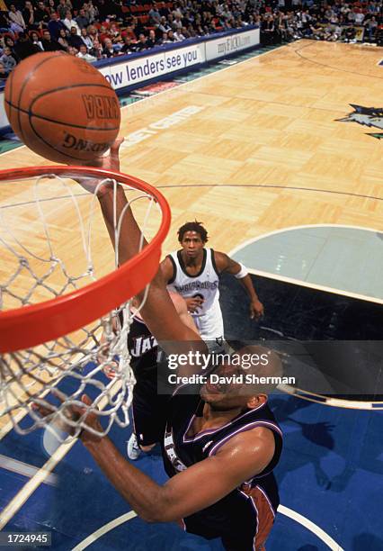 John Amaechi of the Utah Jazz makes a dunk during the NBA game against the Minnesota Timberwolves at Target Center on January 4, 2003 in Minneapolis,...