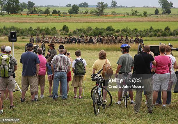 Tourists watch Confederate Civil War re-enactors on the 150th anniversary of the historic Battle of Gettysburg on July 2, 2013 in Gettysburg,...