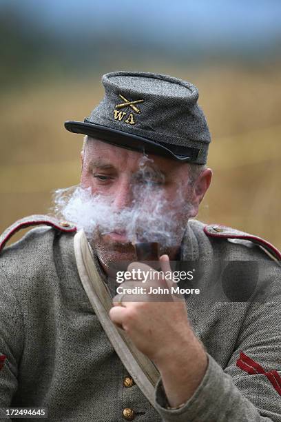 Confederate Civil War re-enactor smokes a pipe before an artillery re-enactment on the 150th anniversary of the historic Battle of Gettysburg on July...