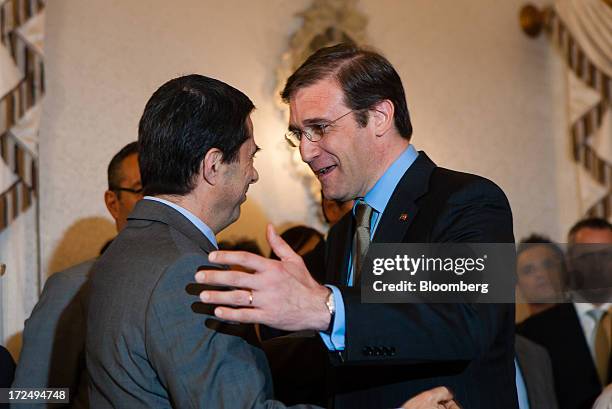 Pedro Passos Coelho, Portugal's prime minister, right, greats Vitor Gaspar, former finance minister, during a swearing in ceremony for new government...
