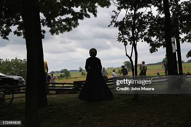 Woman dressed in southern Civil War era attire watches a Confederate re-enactment on the 150th anniversary of the historic Battle of Gettysburg on...