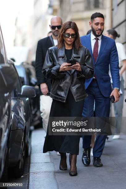Christine Centenera wears sunglasses, a black leather jacket, a black long dress, outside Victoria Beckham, during the Womenswear Spring/Summer 2024...