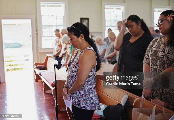 Hyalene Crewe and other members of Lahaina United Methodist Church, which was destroyed in the August 8th wildfire, pray during Sunday services at...
