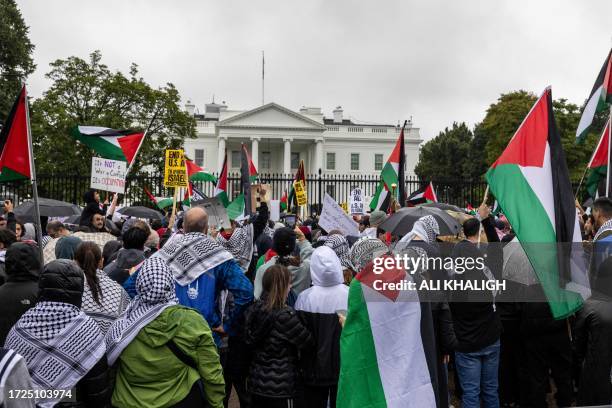 Washington, D.C., USA. Demonstrators hold up placards and Palestinian flags as they take part in a rally in solidarity with Palestine near the White...
