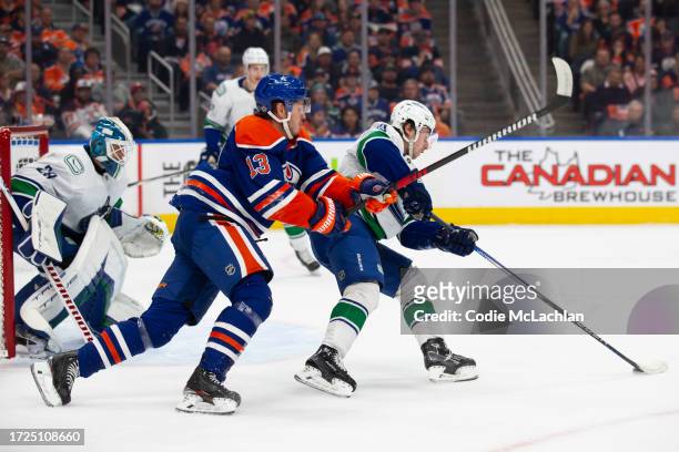 Mattias Janmark of the Edmonton Oilers battles against Quinn Hughes of the Vancouver Canucks during the first period at Rogers Place on October 14,...