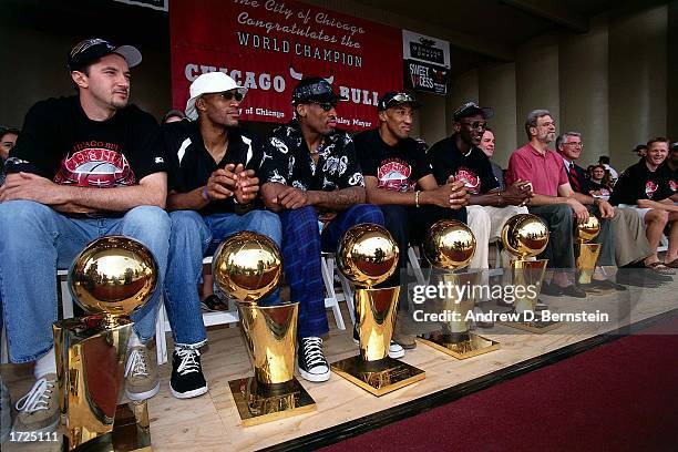 Toni Kukoc, Ron Harper, Dennis Rodman, Scottie Pippen, Michael Jordan, and head coach Phil Jackson sit behind their six championship trophies prior...