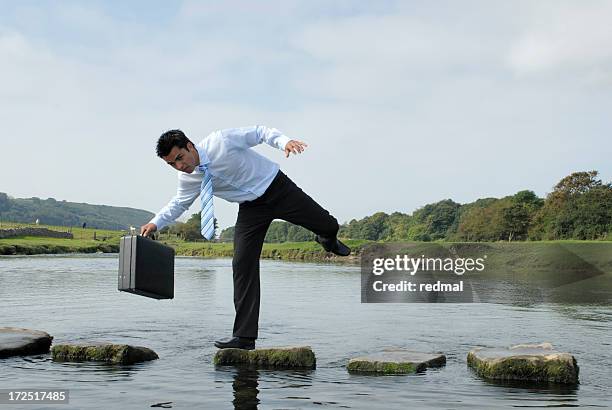 man losing his balance on a rock near a pond  - 絆 個照片及圖片檔