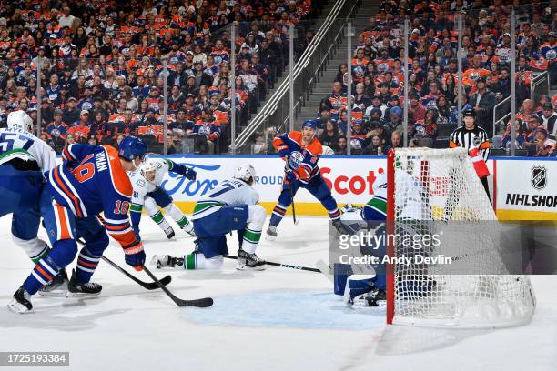 Connor McDavid of the Edmonton Oilers attempts to make a pass during the game against the Vancouver Canucks at Rogers Place on October 14 in...