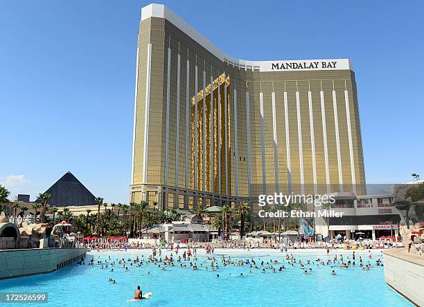 Lifeguard on a surfboard watches over guests playing in the wave pool at the Mandalay Bay Beach at the Mandalay Bay Resort and Casino to escape the...