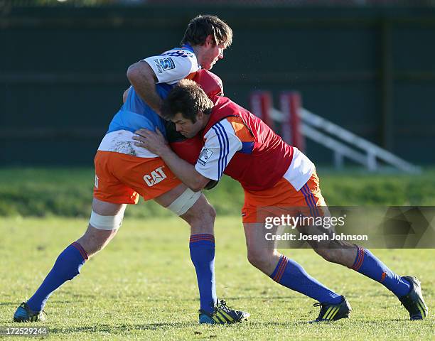 Richie McCaw tackles Tom Donnelly with tackle a bag during a Crusaders Super Rugby training session at Rugby Park on July 3, 2013 in Christchurch,...