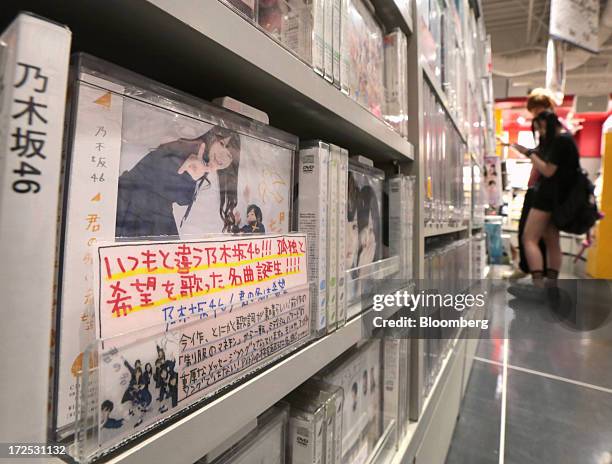 Music CDs and DVDs by "Nogizaka 46", a Japanese girl group, are displayed on a shelf at a Tower Records Japan Inc. Store in Tokyo, Japan, on Monday,...