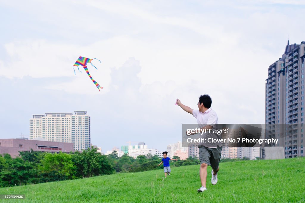 Father and son fly a kite.