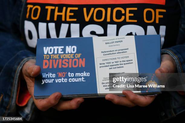 Campaigner holds a 'How to vote No' pamphlet outside a polling centre in the central business district on October 09, 2023 in Sydney, Australia. A...