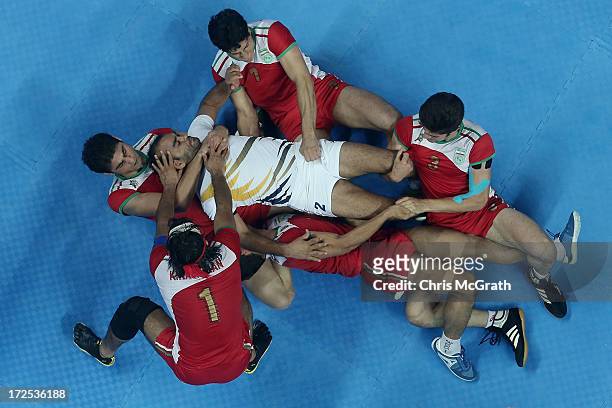 Anup Kumar of Independent Olympic Athletes is tackled by the Iran defence during the Men's Kabaddi Gold Medal match at Ansan Sangnoksu Gym on day...
