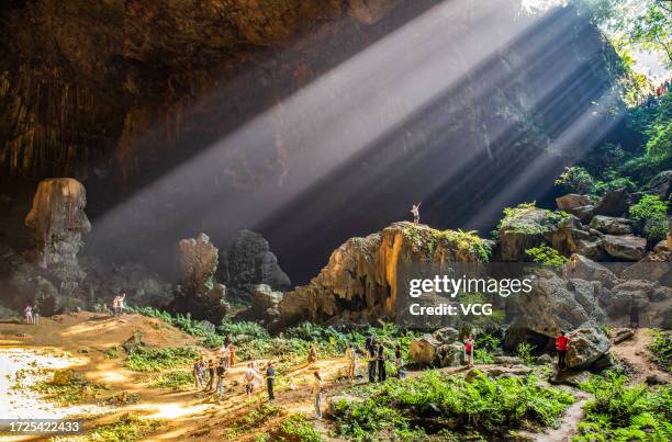 Sunlight scatters as it passes through the giant karst sinkhole, also called tiankeng, or "heavenly pit", on October 6, 2023 in Hechi, Guangxi Zhuang...