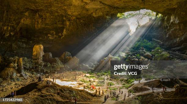 Sunlight scatters as it passes through the giant karst sinkhole, also called tiankeng, or "heavenly pit", on October 6, 2023 in Hechi, Guangxi Zhuang...