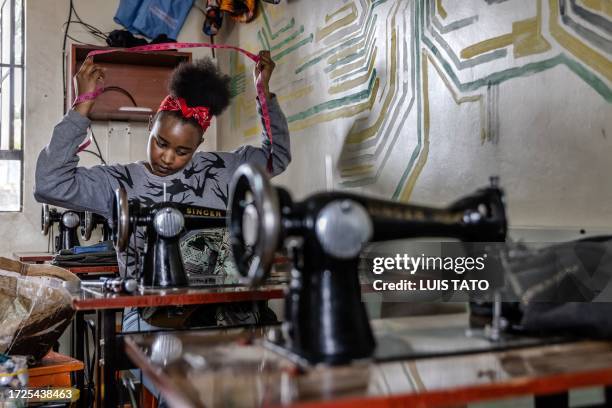 Fashion designer Hellen Wanjiru works on one of her designs at a sewing workshop in Nairobi, on September 25, 2023 ahead of the Kibera Fashion Week....