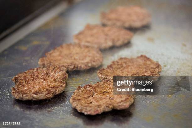 Beef patties or hamburgers sit on a griddle as they cook in the ktchen at U.S. Burger restaurant chain Five Guys in London, U.K., on Tuesday, July 2,...