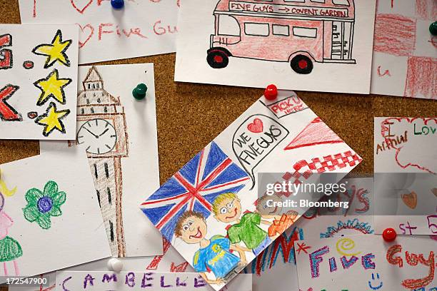 Drawings depicting British items, including a London bus, and Big Ben, are seen on a pin board inside U.S. Burger restaurant chain Five Guys's new...