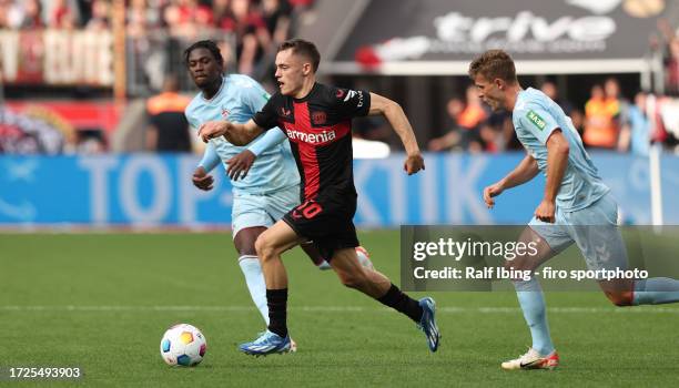 Florian Wirtz of Bayer 04 Leverkusen and Rasmus Carstensen of 1. FC Köln battle for the ball during the Bundesliga match between Bayer 04 Leverkusen...