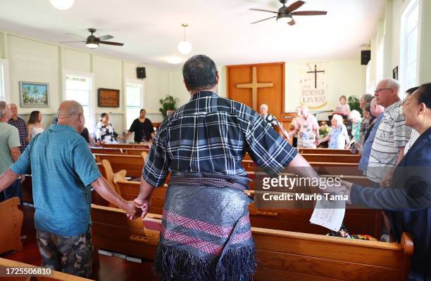 Members of Lahaina United Methodist Church, which was destroyed in the wind-whipped wildfire on August 8th, sing the 'Hawaii Aloha' in a prayer...