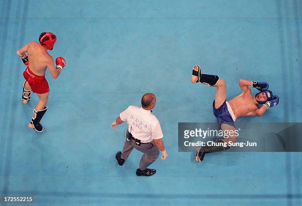 Artur Saurbayev of Kazakhstan is knocked down by Aleksei Fedoseev of Kyrgyzstan in the Kickboxing, Full Contact Men's 63.5kg Round of 16 at Dowon...