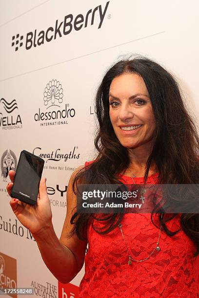 Christine Neubauer poses with a Blackberry Z10 smartphone at the Blackberry Style Lounge during Mercedes-Benz Fashion Week in Berlin on July 3, 2013...