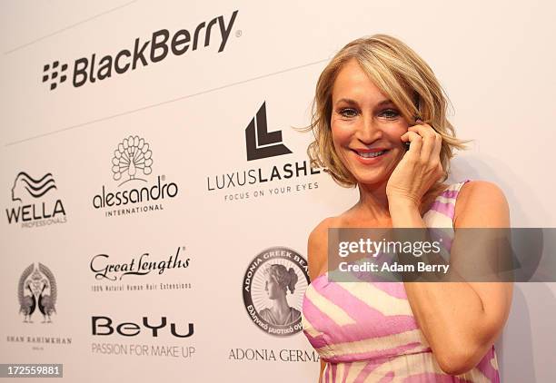 Caroline Beil poses with a Blackberry Z10 smartphone at the Blackberry Style Lounge during Mercedes-Benz Fashion Week in Berlin on July 3, 2013 in...