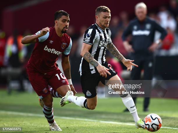 Kieran Trippier of Newcastle United runs with the ball whilst under pressure from Lucas Paqueta of West Ham United during the Premier League match...