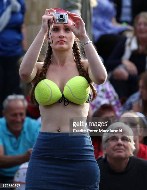 Spectator wearing a tennis ball bikini top photographs a giant TV screen showing Britain's Andy Murray beating Fernando Verdasco of Spain to reach...