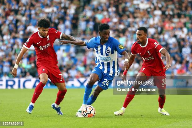 Luis Diaz of Liverpool, Simon Adingra of Brighton and Ryan Gravenberch of Liverpool battle for possession during the Premier League match between...