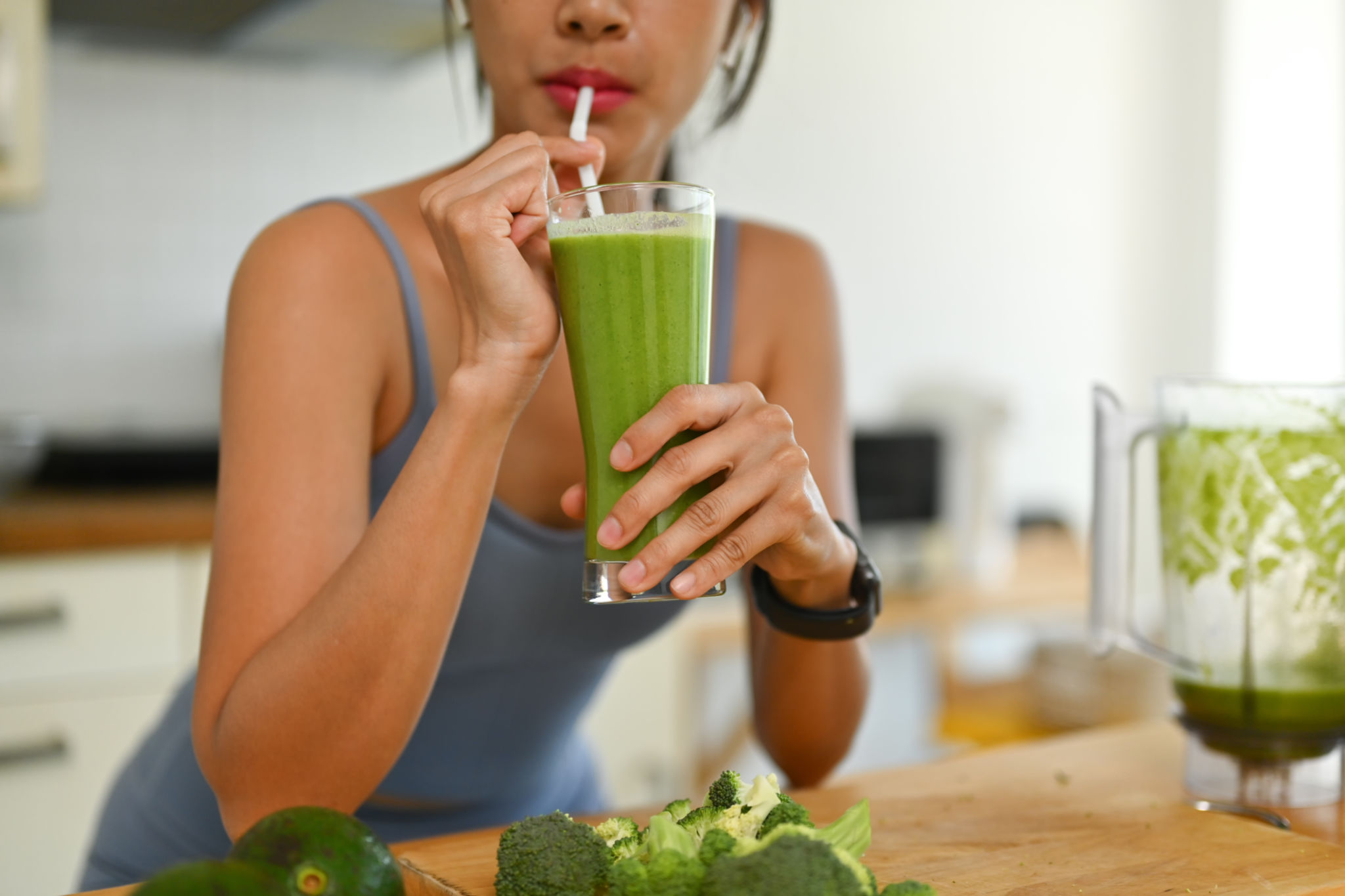 Shot of young woman in sportswear drinking green vegetables smoothie after her morning workout Shot of young woman in sportswear drinking green vegetables smoothie after her morning workout