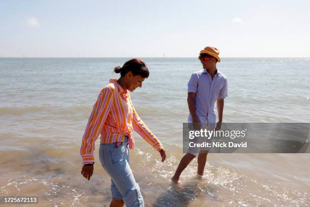 a young couple spending time at the beach paddling in the sea - ankle deep in water stock pictures, royalty-free photos & images