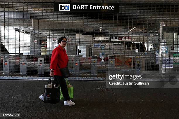 Pedestrian walks by closed pay gate at the Bay Area Rapid Transit Daly City station on July 3, 2013 in Daly City, California. For a third day,...