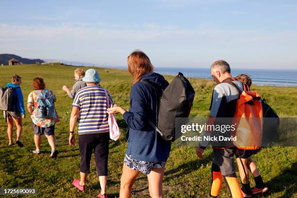 a mixed group of senior adults walking on a coastal path - confidence male landscape stock pictures, royalty-free photos & images