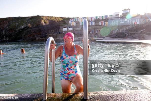 a senior women enjoying a swim at a tidal swimming pool - swimming stock pictures, royalty-free photos & images