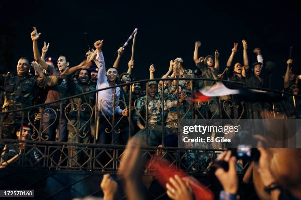 Egyptian opposition protesters and officers of the Egyptian Republican Guard celebrate at the gates of the Republican Guard headquarters in the...