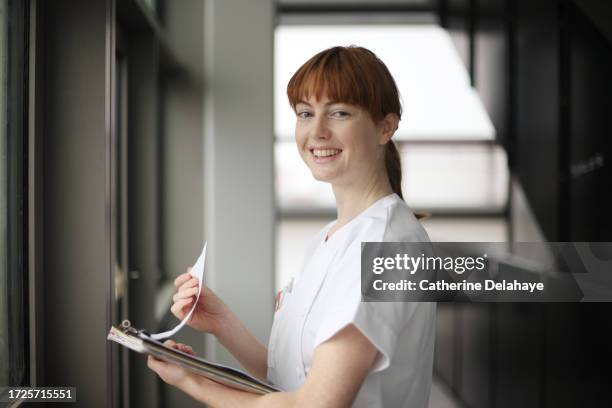 a nurse posing in a hospital corridor - female nurse stock pictures, royalty-free photos & images