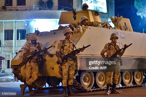 Egyptian Army soldiers patrol the streets outside Cairo University after a broadcast confirming that the army will temporarily be taking over from...