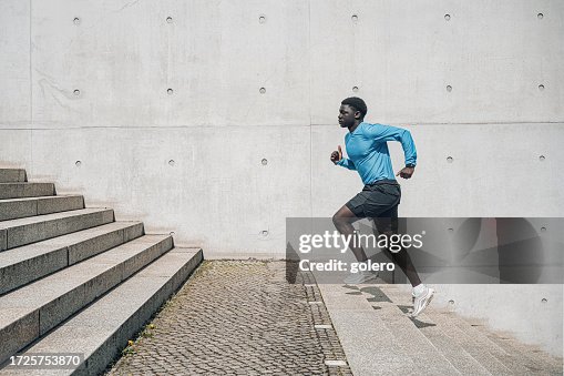 Junger Sportler läuft Stufen im Freien in Berlin hinauf Junger Sportler läuft Stufen im Freien in Berlin hinauf
