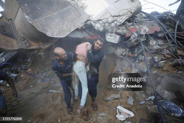 Man carries a body of a dead girl pulled from rubble of building hit by Israeli airstrike in Deir Al-Balah, Gaza on October 15, 2023. Civil defense...